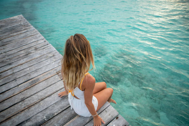 Meisje op pier Cheerful young woman on wooden pier above tropical reef sea; Girl having fun laughing on vacations
